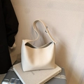 Minimalist soft cream leather tote bag with wide strap on a silver suitcase - Off White