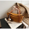 Tragetasche aus Wildleder in Karamel mit Baseball-Anhänger vor beigem Trenchcoat - Karamell (Mit Anhänger)