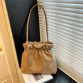 Khaki suede leather bucket bag with cloud pleats and a thin strap in a modern setting - Khaki