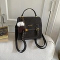 Détail du sac à dos vintage marron foncé avec boucles dorées et breloque gant en peluche - Ébène (Avec Charme)