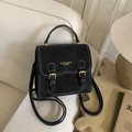 Schwarzer Retro-Lederrucksack mit weißen Nähten und Goldbuckles in häuslicher Kulisse - Schwarz (Ohne Anhänger)