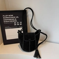 Black suede bucket bag with white contrast stitching and trendy tassel detail - Black