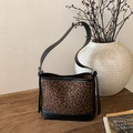Macro shot of leopard print texture and black leather stitching on a vintage tote bag - Leopard Print