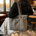 Bolso tote acolchado verde salvia con múltiples bolsillos en un ambiente acogedor - Verde