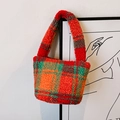 Plaid plush bucket handbag featuring vibrant red, orange, and green checkered faux fur - Orange Red