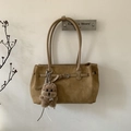 Detail of khaki tote bag featuring a leather buckle strap and a brown plush bear charm - Khaki