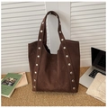 Detailed texture of dark brown suede tote bag with silver rivets on shoulder straps - Brown