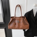Dettaglio della borsa tote marrone vintage con pendente a croce metallica e catenina - Marrone