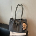 Sage green woven leather tote bag featuring a plush teddy bear charm and sleek shoulder strap - Gray With Pendant