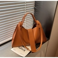 Detalle del bolso hobo naranja caramelo con textura litchi y estructura trapezoidal - Marrón