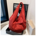 Dettaglio della borsa a tracolla in nylon rosso con tasche multiple e tessuto impermeabile - Rosso