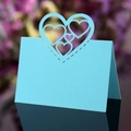 Macro shot of light blue laser-cut heart seat card with intricate hollow pattern - Tiffany Blue