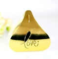 Close-up of golden triangular wedding candy box with laser-cut LOVE text design - Reflective Gold