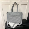 Light grey quilted tote bag with dual front pockets and adjustable wide shoulder strap - Gray