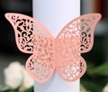 Détail de l'anneau de serviette papillon découpé au laser avec motifs floraux délicats - Rose