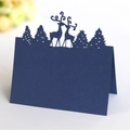 Laser-cut navy blue Christmas reindeer and pine tree place card on white surface - Sapphire Blue