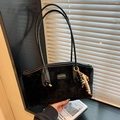 Fashionable black faux fur shoulder bag with gold logo plaque and beaded charm - Black