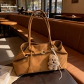 Borsa tote marrone in pelle scamosciata con ciondolo a forma di cane in un caffè accogliente - Con Ciondolo / Marrone
