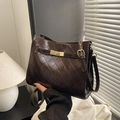 Dunkelkaffeebraune Stepp-Schultertasche mit goldenem Drehverschluss in stilvoller Handpose - Braun