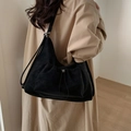 Minimalist black matte tote bag with drawstring texture shown on a beige coat model - Black