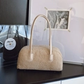Beige faux shearling bowling bag with leather handles in an artistic vintage setting - Khaki