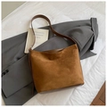 Détail du sac hobo en daim caramel avec garniture en cuir foncé et boucles métalliques - Marron