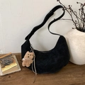 Detail of black suede crescent bag with plush bear charm and long tassel on wooden bench - Black with Pendant