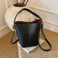 Minimalist black lychee texture leather bucket bag with top handle and crossbody strap - Black