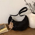 Detailed close-up of a black suede crescent bag with a cute plush dog pendant charm - Ebony with Pendant