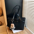Sac fourre-tout noir chic avec boucles dorées et charm de chien dans un décor moderne - Noir avec pendentif