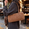 Fashionable caramel brown matte leather shoulder bag worn with an autumn wool coat - Brown