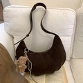 Dark brown suede crescent bag with bear pendant and woven tassel on white sofa - Coffee with Pendant