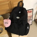 Detalle de mochila negra de nailon con cordón y mini monedero de corazón rosa - Negro