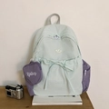 Detalle de la mochila verde menta con bolsillo púrpura y colgante en forma de corazón - Azul