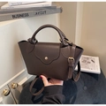 Detailansicht der dunkelbraunen Lederstruktur und goldener Schnalle der Eimertasche - Kaffeebraun