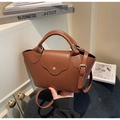 Detailaufnahme der braunen Handtasche aus Leder mit eleganter goldener Hardware - Braun