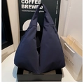 Makro-Detail der marineblauen dreieckigen Nylon-Tasche mit funktionalem Seitenreißverschluss - Blau