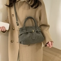 Greyish-green faux suede crossbody tote bag with gold hardware on camel wool coat - Green