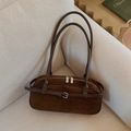 Detailed view of brown suede handbag with belt buckle detail on a white sofa - Brown