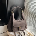 Detalle del bolso hobo con bolsillo frontal, hebilla dorada y cuero mate gris pardo - Gris