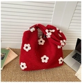 Macro shot of red knitted tote bag with large white floral patterns and thick texture - Flower Red