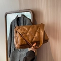 Brown quilted crossbody bag with wide strap and gold buckle in a minimalist chic style - Khaki