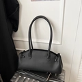 Detail van zwarte tas van lychee-leer met plooiontwerp op een koffer geplaatst - Zwart