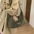 Olive green suede crossbody bag with teddy bear charm worn with a trench coat - Green with Pendant