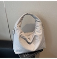 Detailed view of grey quilted hobo bag with zipper knot and soft textured fabric - Gray