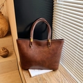 Sac cabas vintage en cuir marron avec détails dorés sur table en bois, style épuré - Marron (Sans Pendentif)