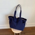 Detalle del bolso tote azul con textura de nailon y bolsillos laterales con cordón - Azul