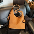 Minimalist ginger yellow leather hobo bag with adjustable strap and decorative scroll charm - Brown