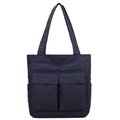 Detalle del bolso tote de nailon azul marino con dos bolsillos frontales con solapa - Azul oscuro