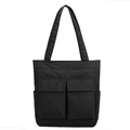 Detail of black utility tote bag showing front flap pockets and durable nylon texture - Black